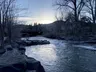 evening photo of Clear Creek, sun down and sky darkening, bare trees