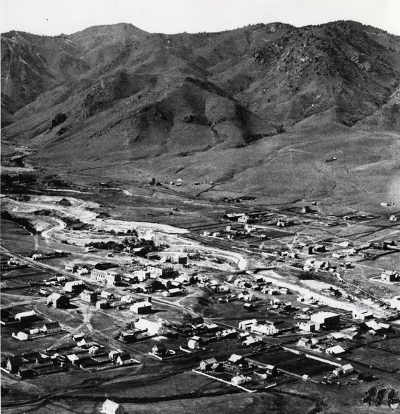 very early photo of Golden, looking down from South Table Mountain-a scattering of buildings, Clear Creek, and mountains