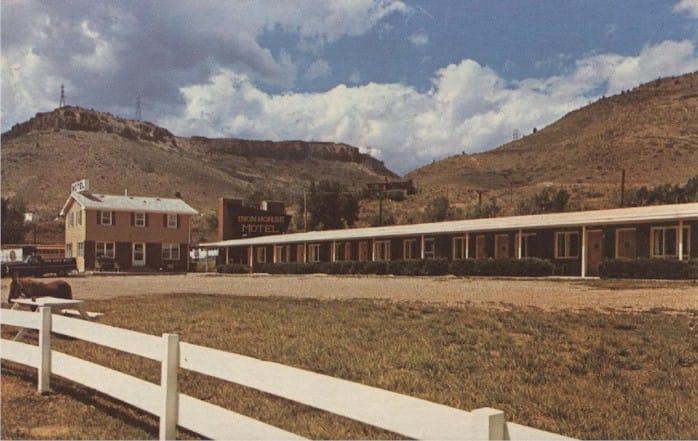 Long, one story motel with North Table Mountain in the background.