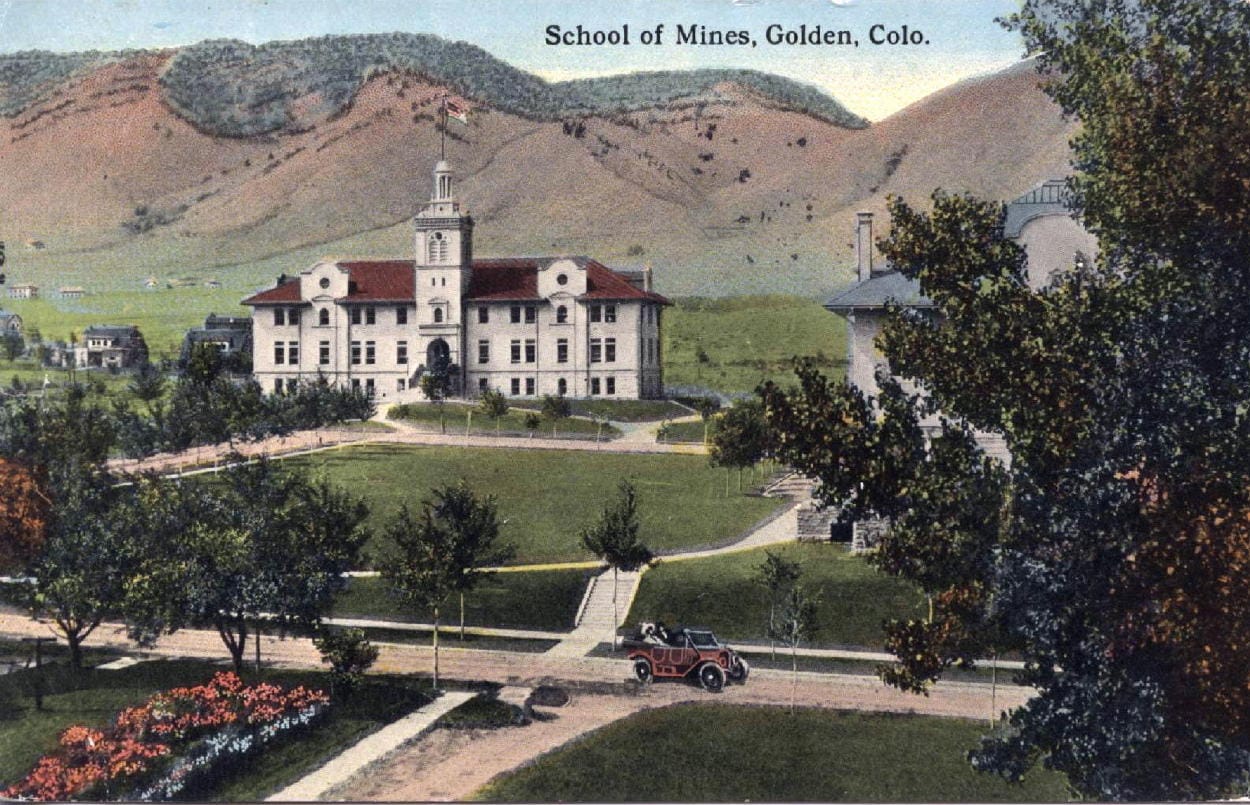 hand-tinted postcard showing Guggenheim Hall and a 20s-style car - mountains in the background