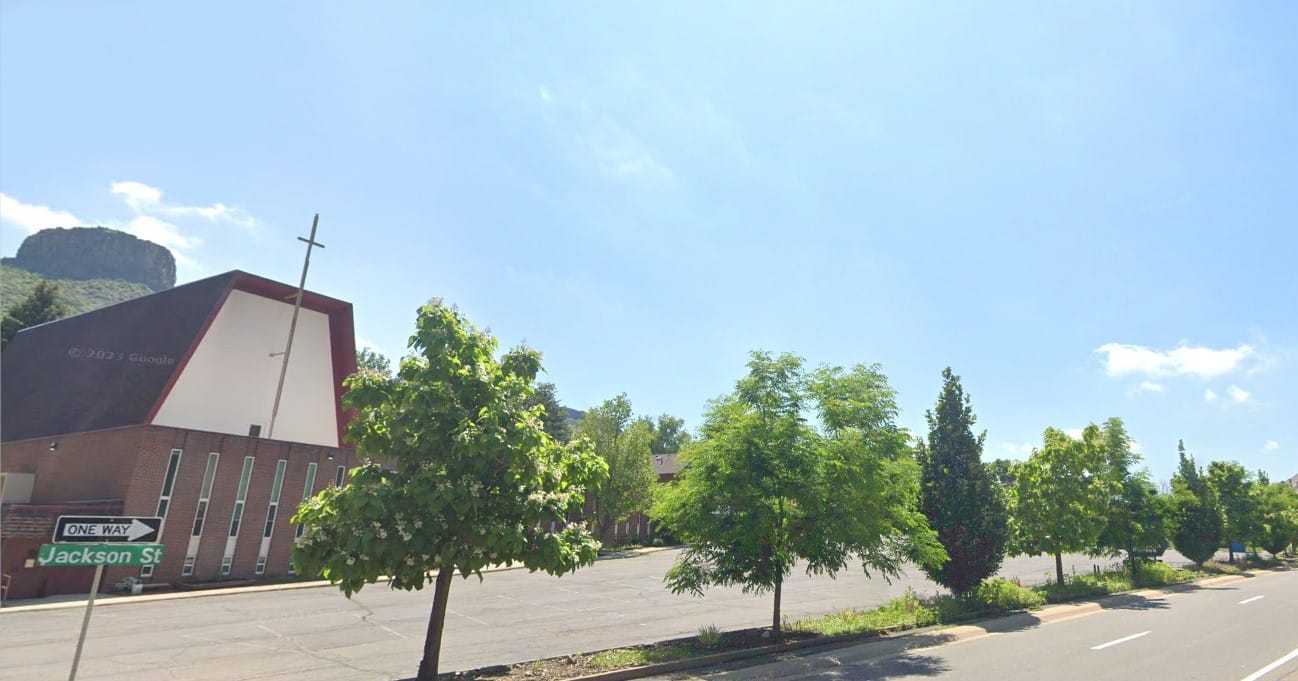 shows a row of trees along the church parking lot