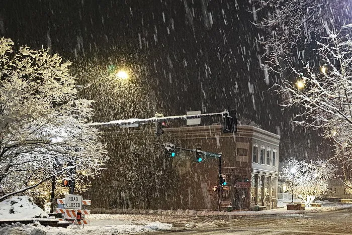 night view across an intersection on a snowy night