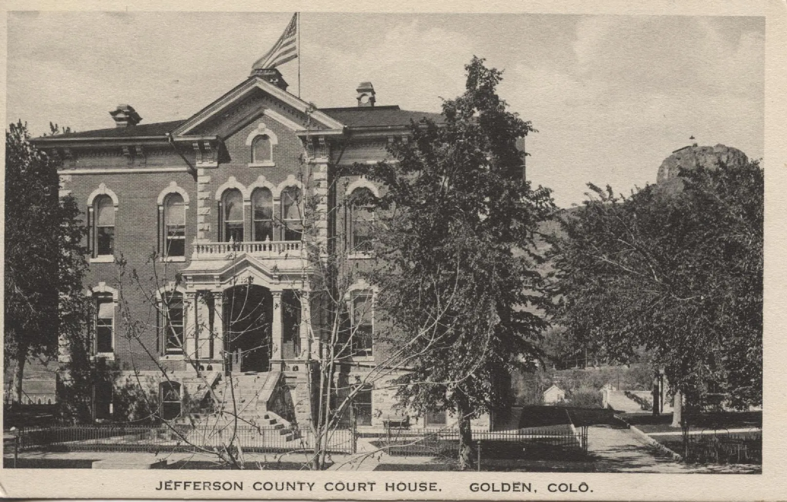 Antique postcard showing the 1878 Jefferson County Court house with Castle Rock in the background.