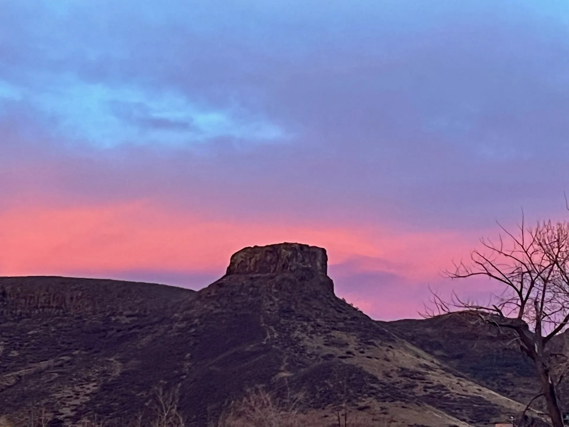 Castle Rock with a bright pink early morning sky in the background.