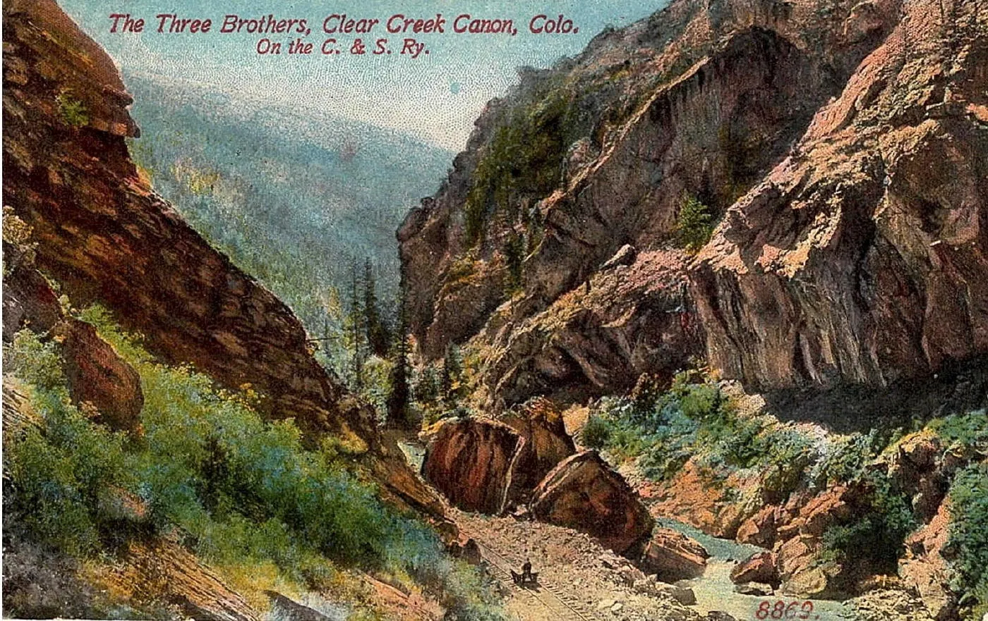 Hand-tinted postcard shows a narrow canyon with red rock walls.  Title labels it "The Three Brothers"