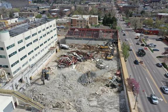 half block section where buildings have been demolished, leaving rubble and piles of metal.  Washington Ave runs the right