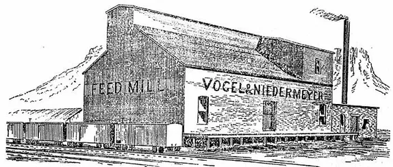 2 story building with FEED MILL sign, freight cars parked alongside