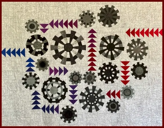 quilt with cream-colored background withaliques of arrows and propellers