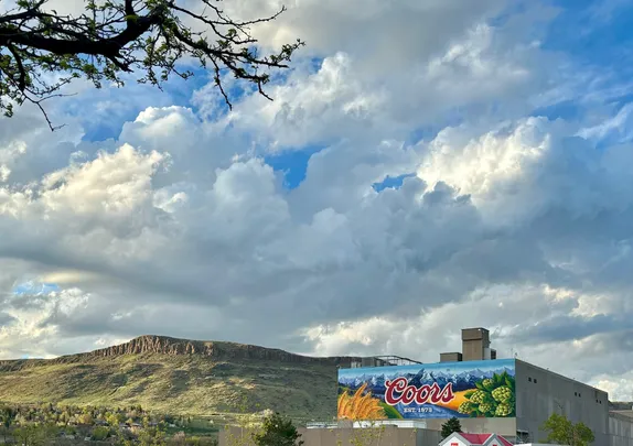 bright blue sky with fluffy clouds, North Table Mountain the Coors mural at the bottom of the page