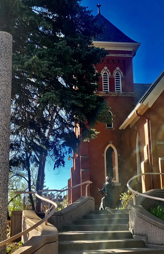 curving stairs and a bell tower with bronze statue of St. Francis of Assissi 