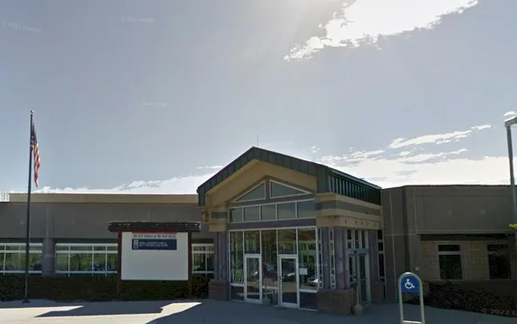 modern-style (steel, concrete, & glass)post office with American flag on pole in front